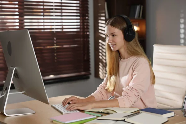 Genç kız çevrimiçi olarak kapalı bir masada çalışıyor.