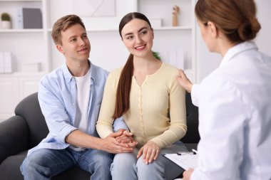 Tüp bebek (tüp bebek). Doktor çiftleri üreme kliniğine giderken teşvik ediyor.