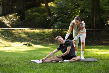 Genç adam dışarıda profesyonel antrenörle egzersiz yapıyor. Metin için boşluk