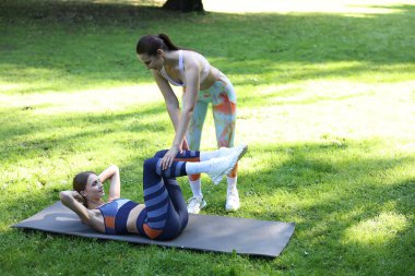 Dışarıda profesyonel antrenörle egzersiz yapan genç bir kadın. Metin için boşluk