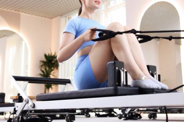 Pilates stüdyosunda yenilikçi kadın egzersizi, yakın çekim.