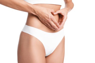 Düz göbekli kadın, beyaz arka planda kalp hareketi yapıyor, yakın plan.