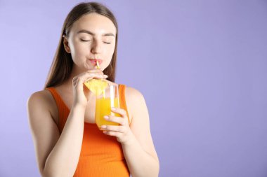 Kadın menekşe arka planında samandan ferahlatıcı içecek içiyor, metin için yer var.