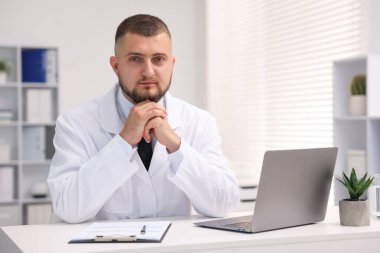 Klinikte dizüstü bilgisayarla çalışan bir doktor. Online tıbbi danışmanlık
