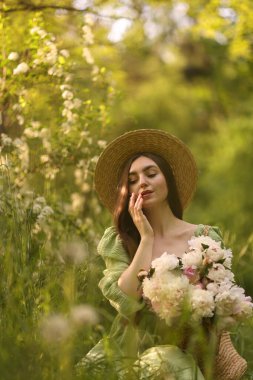 Parkta şakayık demeti olan güzel bir kadın.