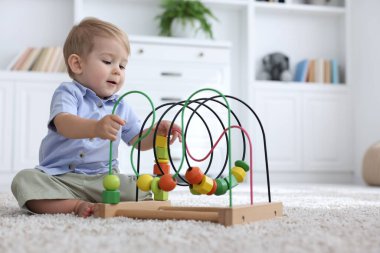 Evde yerde oyuncaklarla oynayan şirin bir bebek.