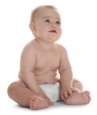 Beyaz arka planda oturan, bebek bezi takmış şirin bir bebek.