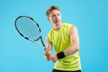 Açık mavi arka planda tenis raketi olan bir adam.