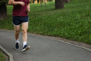 Spor giyimli atletik genç adam dışarı koşuyor, yakın plan. Metin için boşluk
