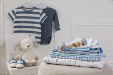 Temiz bebek kıyafetleri ve içeride pelte üzerinde oyuncak yığını.