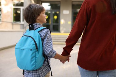 Anne oğlunu açık hava okuluna götürüyor.