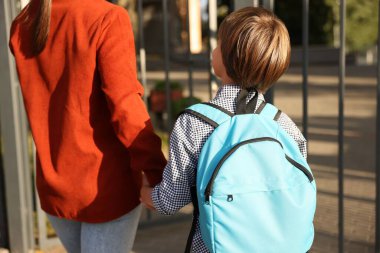 Anne oğlunu açık hava okuluna götürüyor.