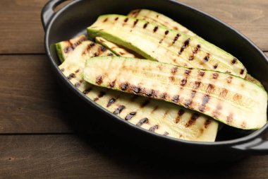 Ahşap masadaki fırında pişmiş kabak dilimleri, yakın plan.