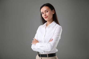 Gri arka planda kendine güvenen bir iş kadınının portresi