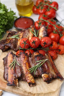 Biberiyeli biftek kaburgaları, domatesler ve diğer ürünler masada, yakın plan.