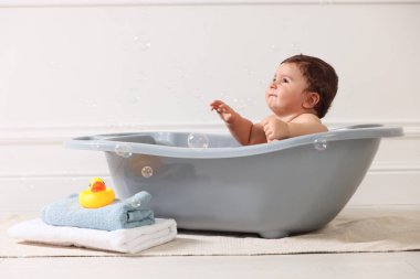 Evde küvette banyo yapan şirin bir bebek.