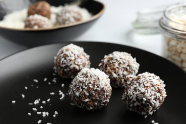 Beyaz masada hindistan cevizi taneli lezzetli çikolatalar, yakın plan.