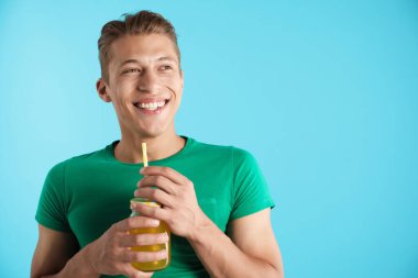 Meyve suyu ve açık mavi arka planda saman içen adam, metin için boşluk