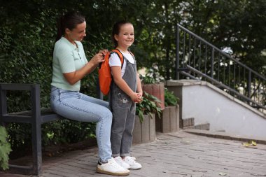 Anne kızını açık hava okuluna götürüyor.