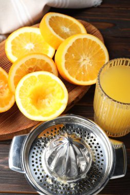 Taze sıkılmış portakal suyu, meyve suyu ve meyve sıkacağı ahşap masada, yukarıda.