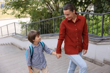 Anne oğlunu açık hava okuluna götürüyor.