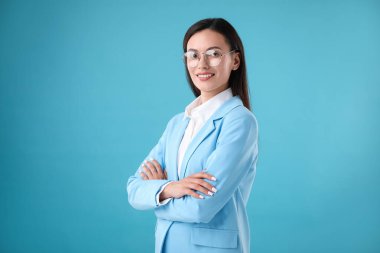 Açık mavi arka planda kendine güvenen bir iş kadını portresi