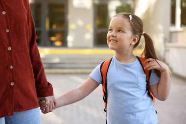 Anne kızını açık hava okuluna götürüyor, yakın çekim.