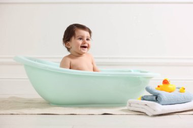 Evde küvette banyo yapan şirin bir bebek.