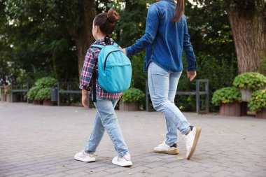 Anne kızını açık hava okuluna götürüyor.