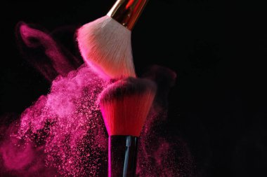 Siyah arka planda pembe göz farlı makyaj fırçaları, yakın plan