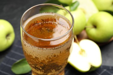 Bardakta taze elma şarabı, masada, yakın plan.