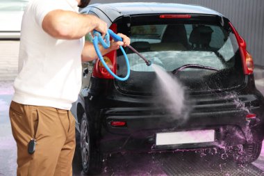 Oto yıkayan adam yüksek basınçlı su jeti ile oto yıkama, yakın çekim