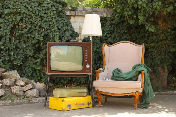 Retro TV stantta, koltuk ve diğer kullanılmış eşyalar dışarıda.
