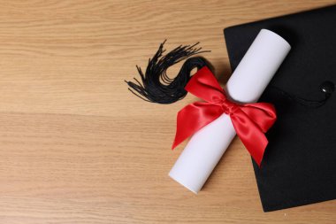 Mezuniyet şapkası ve diploması tahta masada, düz yatıyordu. Metin için boşluk