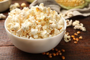 Tahta masada lezzetli patlamış mısır ve mısır taneleri, yakın plan.