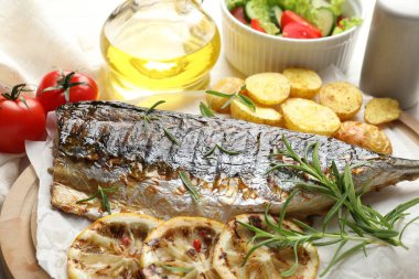 Masada patates ve salatayla servis edilen lezzetli kızarmış uskumru, yakın plan. Ev yapımı deniz ürünleri yemeği.