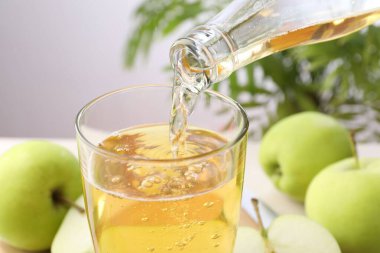Masadaki bardağa taze elma şarabı dök, yakından.