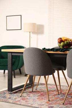 Yemek odasındaki ahşap masada bir kase meyve. İç tasarım