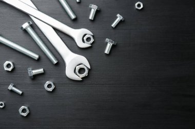 Bir sürü metal anahtar, cıvata ve somun siyah ahşap masa, düz yatıyordu. Metin için boşluk