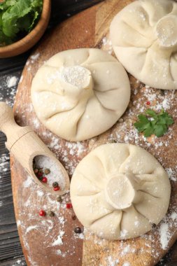 Ahşap masada baharat ve maydanozlu pişmemiş khinkali (hamur tatlısı), düz.