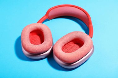 Açık mavi arka planda bir çift şık pembe kulaklık.