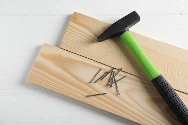 Çekiç, metal çiviler ve tahta tahtalar beyaz masa, düz yatıyordu.