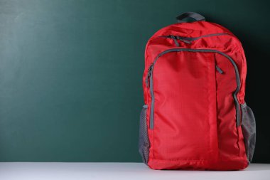 Masanın yanındaki kırmızı sırt çantası. Metin için boşluk