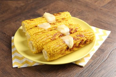 Ahşap masada soslu lezzetli mısır koçanları.