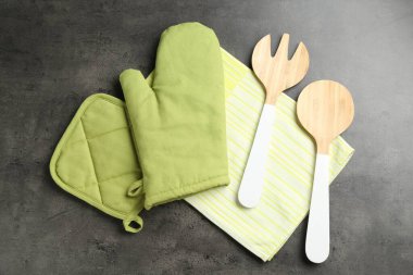 Yeşil fırın eldiveni ve diğer mutfak gereçleri koyu dokulu masa, düz yatıyordu.