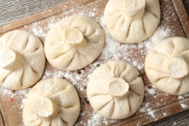 Ahşap masa üzerinde pişmemiş khinkaliler (hamur tatlısı), üst görünüm