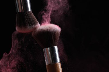 Siyah arkaplanda renk farlı makyaj fırçaları, yakın plan