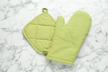 Fırın eldiveni ve tutacağı beyaz mermer masada, düz yatıyordu.