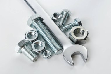 Beyaz arka planda metal anahtar, cıvata ve fındık