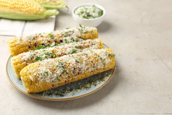 Masanın üzerinde maydanozlu ve peynirli kızarmış mısır koçanları.